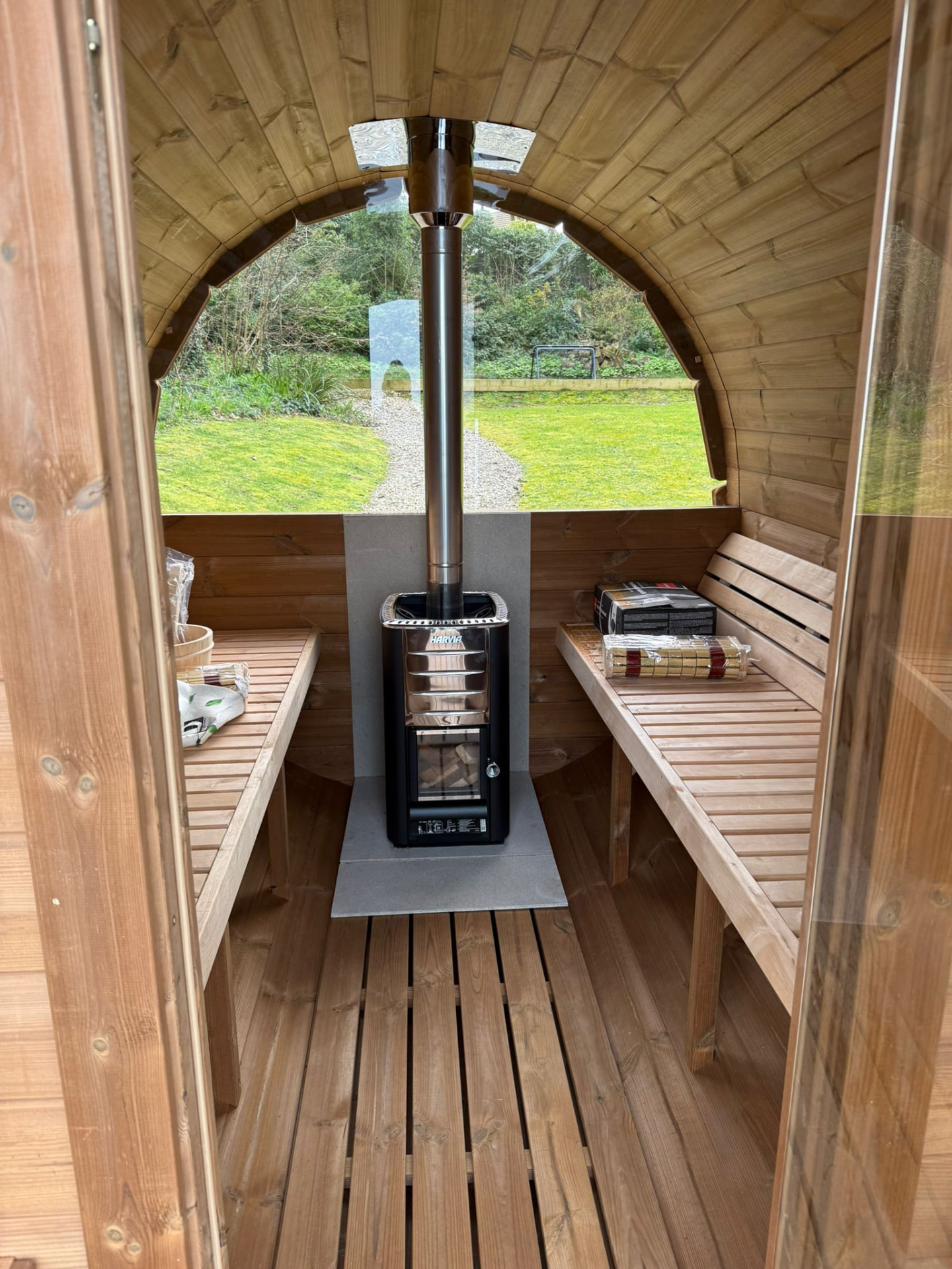 Barrel sauna interior with cedar benches and a Harvia stove